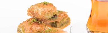 Lezzetli Türk baklavası ve çay beyaz panoramik çekimde izole edilmiş.