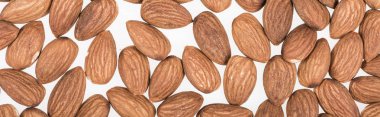 top view of almond nuts scattered isolated on white, panoramic shot clipart