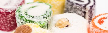 close up view of assorted delicious turkish delight in coconut flakes isolated on white, panoramic shot clipart