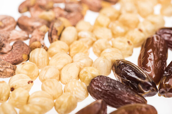 close up view of dried dates, hazelnut and cashew isolated on white