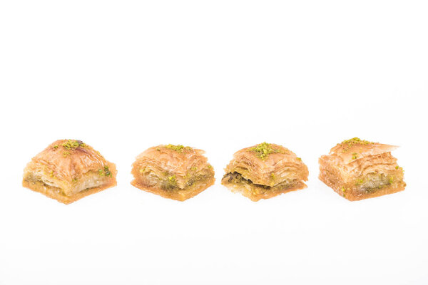 traditional turkish honey baklava with nuts in row isolated on white