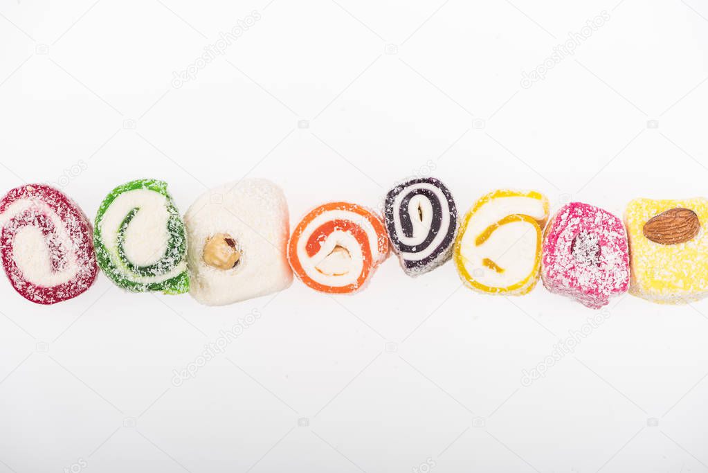 top view of assorted delicious turkish delight in coconut flakes in row isolated on white