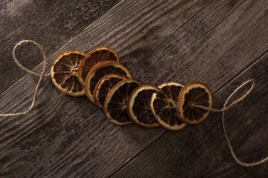 Ahşap yüzeyde kurutulmuş portakal dilimlerinin üst görüntüsü.
