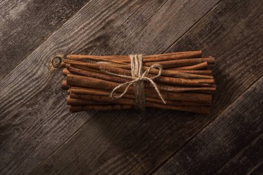 top view of cinnamon sticks in bunch on wooden rustic table clipart