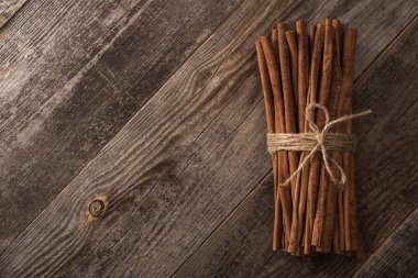 top view of cinnamon sticks in bunch on wooden rustic table with copy space clipart