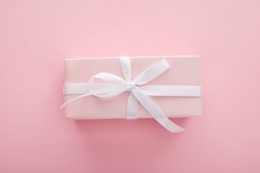 Pembe arka planda beyaz kurdeleli pembe hediye manzarası