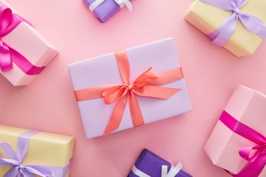 top view of colorful gift boxes with ribbons and bows on pink background clipart