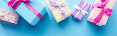top view of colorful gift boxes on blue background, panoramic shot clipart