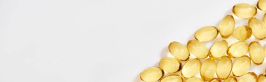 flat lay with golden fish oil capsules on white background, panoramic shot clipart