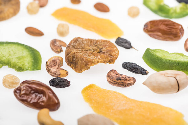 close up view of tasty assorted nuts, dried fruits and candied fruit isolated on white