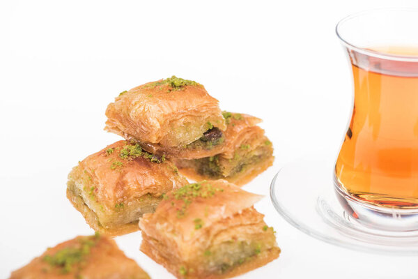 close up view of cup of tea near baklava isolated on white
