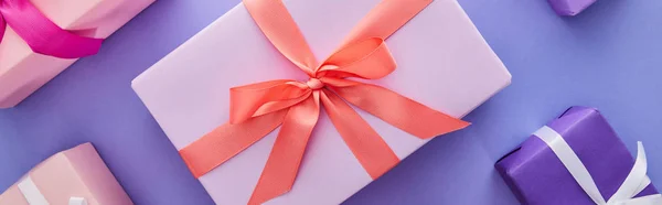 紫色の背景に弓でカラフルなプレゼントとフラットレイ パノラマショット — ストック写真