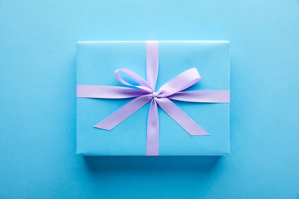 Вид Зверху Блакитного Подарунка Фіолетовою Стрічкою Синьому Фоні — стокове фото