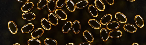 Top View Golden Fish Oil Capsules Black Background Dark Panoramic — Stock Photo, Image