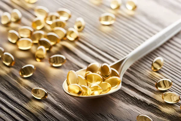 Golden Fish Oil Capsules Spoon Wooden Table — Stock Photo, Image