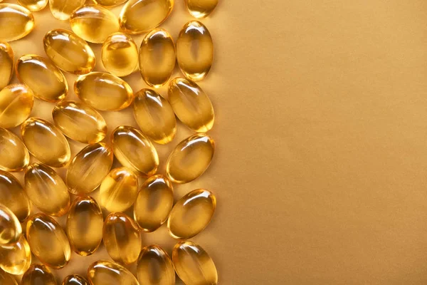 Top View Golden Shiny Fish Oil Capsules Yellow Background Copy — Stock Photo, Image