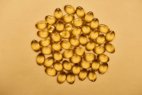 Top View Golden Shiny Fish Oil Capsules Yellow Background — Stok Foto