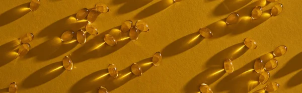 Κορυφαία Άποψη Της Χρυσαφί Κάψουλες Ιχθυέλαιο Διάσπαρτα Κίτρινο Φόντο Σκούρο — Φωτογραφία Αρχείου