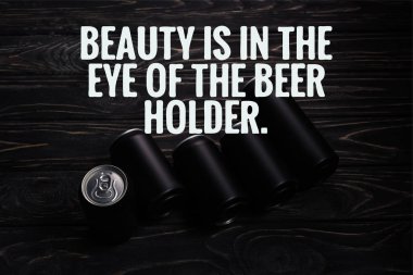 black aluminum cans of beer on wooden table with beauty is in the eye of the beer holder illustration clipart
