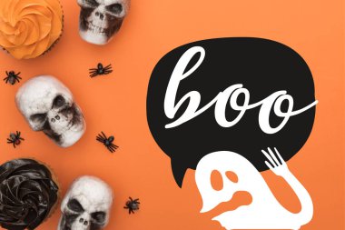 top view of cupcakes, decorative skulls and spiders on orange background with boo and ghost illustration clipart