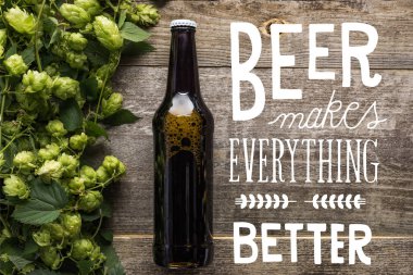 top view of fresh beer in bottle with green hop on wooden surface with white beer makes everything better illustration clipart