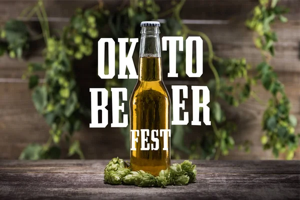Świeże Piwo Butelce Zielonym Chmielem Drewnianej Powierzchni Białym Napisem Oktoberfest — Zdjęcie stockowe