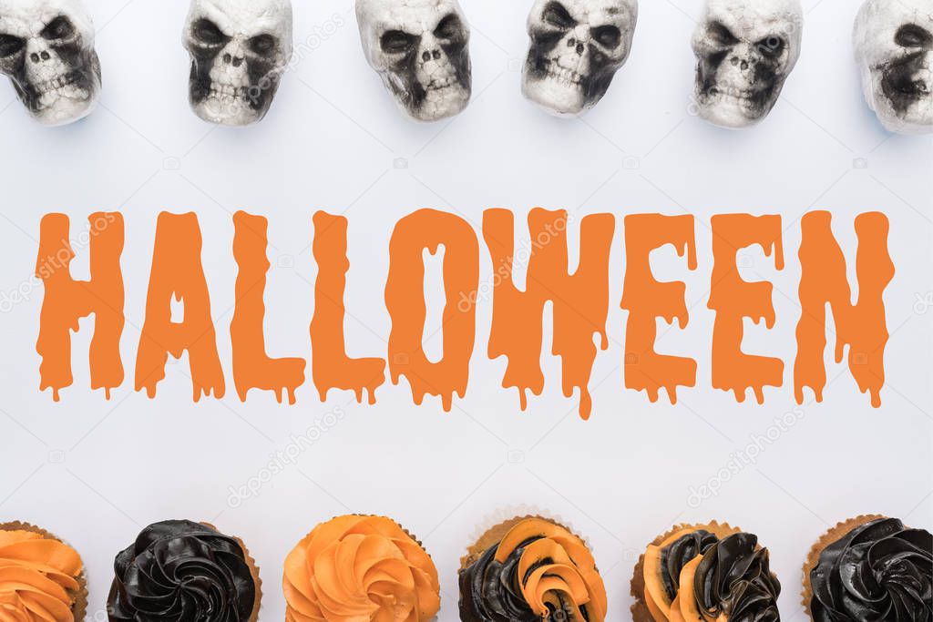 top view of delicious Halloween cupcakes and skulls on white background  with Halloween illustration