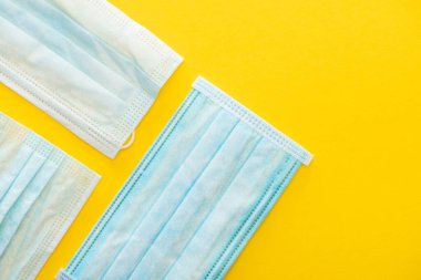 Sarı arka planda tıbbi maskelerin üst görünümü