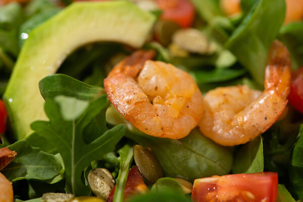 close up view of fresh green salad with shrimps and avocado