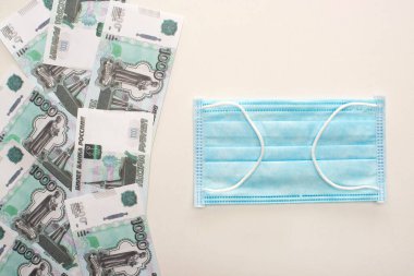 KYIV, UKRAINE - 25 Mart 2020: Tıbbi maskenin üst görüntüsü, beyaz arkaplanda Rus rublesi