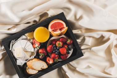 Greyfurtlu Fransız kahvaltısı, Camembert peyniri, portakal suyu, böğürtlen ve ekmeği beyaz masa örtüsü tepsisinde.