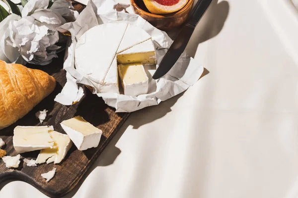 クロワッサン カマンベール 牡丹の白いテーブルクロスに木製のまな板でフランスの朝食のトップビュー — ストック写真