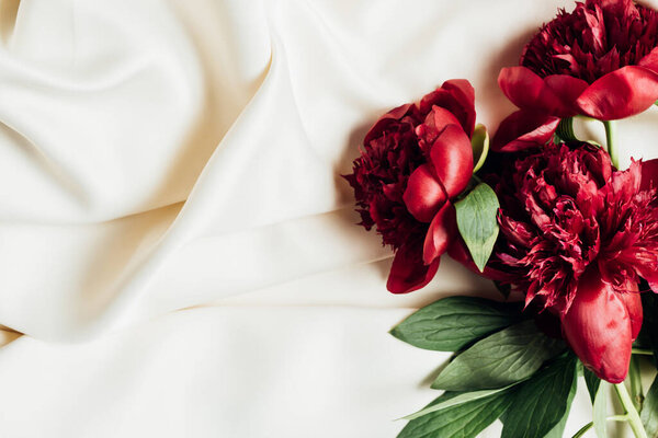 top view of red peonies on white cloth