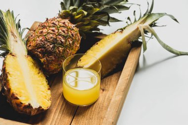 Taze ananas suyu ve beyaz arka planda ahşap tepside lezzetli meyveler.