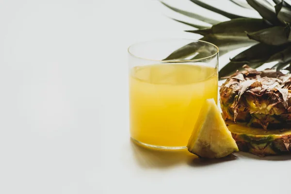 新鲜的菠萝汁在白底切碎美味的水果附近 — 图库照片