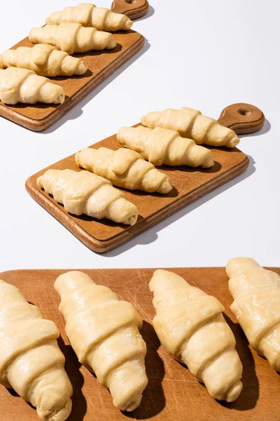 Rauwe Croissants Houten Snijplanken Witte Ondergrond — Stockfoto