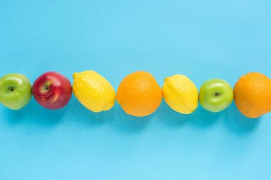 top view of ripe fruits in line on blue background clipart