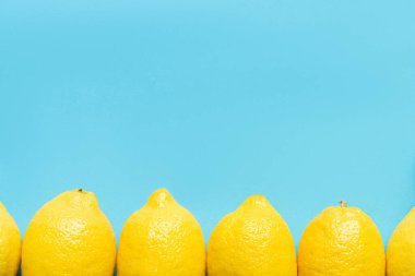 Mavi arkaplandaki olgun sarı limonun üst görünümü kopya alanı ile