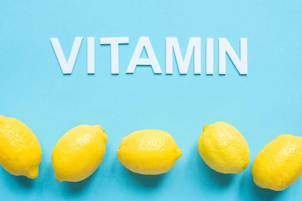 Bovenaanzicht Van Rijpe Gele Citroenen Woord Vitamine Blauwe Achtergrond — Stockfoto