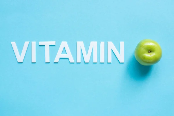 Olgun Yeşil Elma Mavi Zemin Üzerindeki Kelime Vitamininin Üst Görünümü — Stok fotoğraf