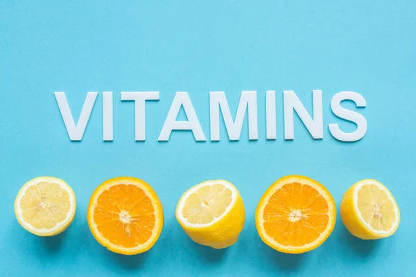 Top View Ripe Orange Lemon Halves Word Vitamins Blue Background — Stock Photo, Image