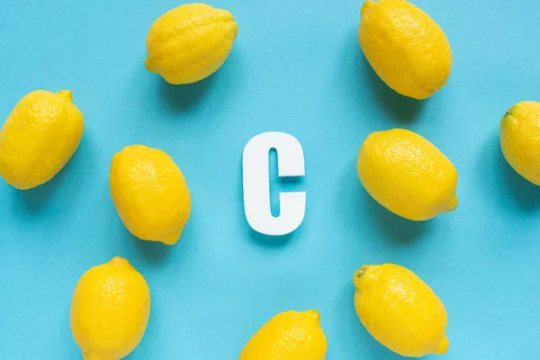 Draufsicht Auf Reife Gelbe Zitronen Und Buchstabe Auf Blauem Hintergrund — Stockfoto