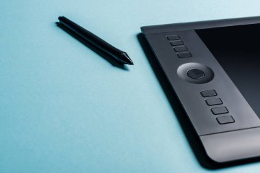 Stylus 'un mavi arkaplan üzerindeki grafik tabletinin yakınındaki görünümünü kopyalama alanı ile kapat