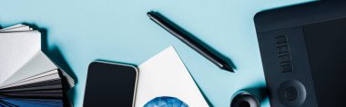 Mavi arkaplanda grafik tableti, akıllı telefon ve renk örneklerinin panoramik görüntüsü