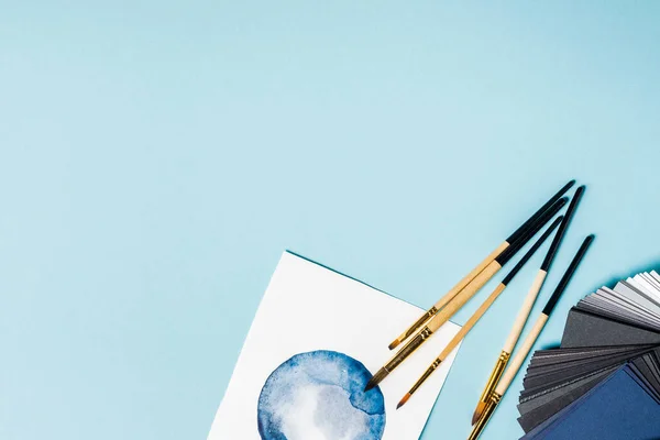 Draufsicht Der Pinsel Auf Aquarellmalerei Und Farbmuster Auf Blauem Hintergrund — Stockfoto