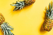 vrchní pohled na čerstvé chutné ananas na žlutém pozadí
