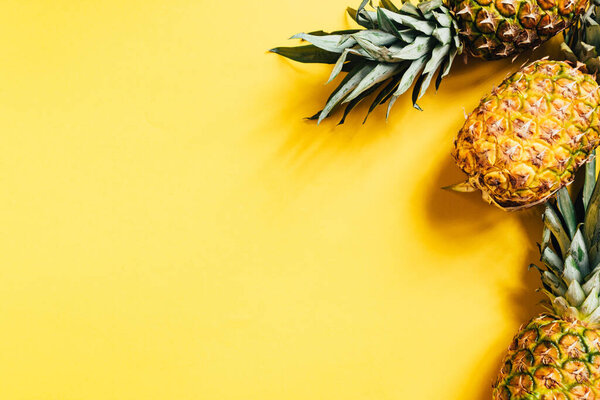 top view of fresh ripe pineapples on yellow background