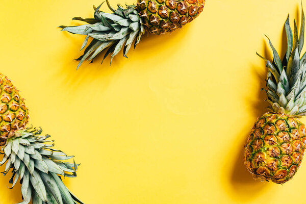 top view of fresh tasty pineapples on yellow background