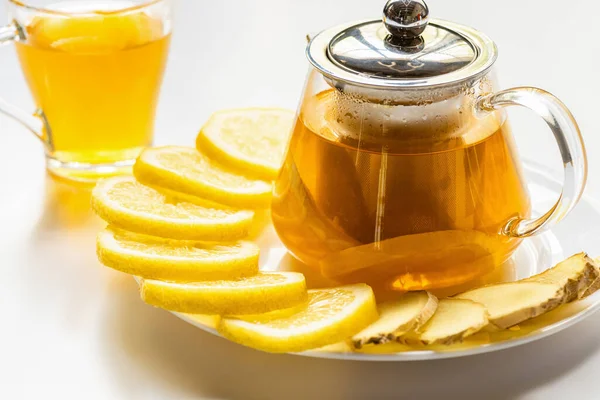 ガラスのティーポットにレモンスライスと生姜と白を基調としたカップで熱々のお茶 — ストック写真