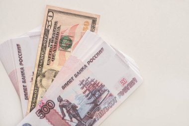 KYIV, UKRAINE - 25 Mart 2020: Ruble ve dolar banknotlarının üst görüntüsü beyaz üzerine izole edilmiş